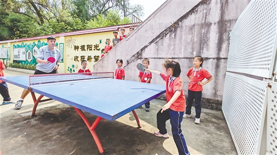 老师与学生在乒乓球桌上“过招”。