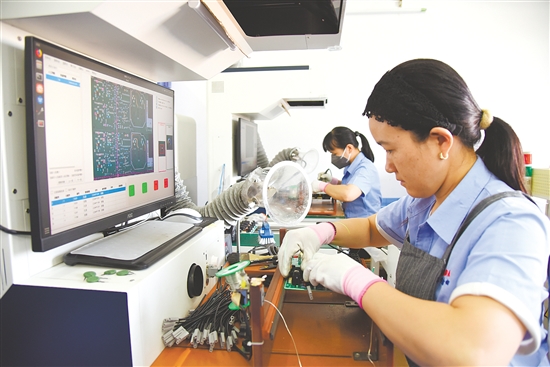 恩平市奥达电子科技有限公司厂房内，工人正在检测电子元器件。