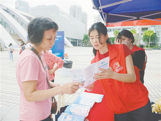工作人员向市民介绍参保流程。