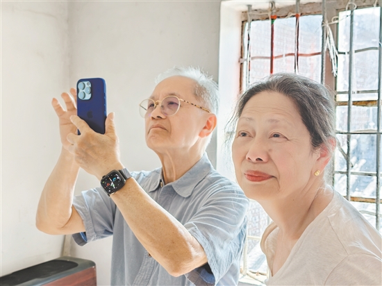 伍爵彬与夫人余纾华探访祖屋期间，多次拿出手机拍照纪念。