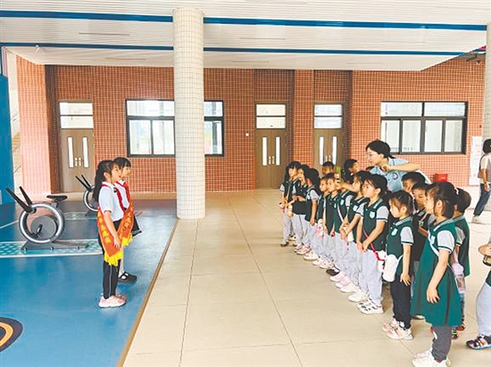 红领巾讲解员带领孩子参观校园。