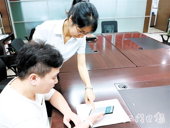 工作人员在指导市民线上交存住宅专项维修资金。陆沿任