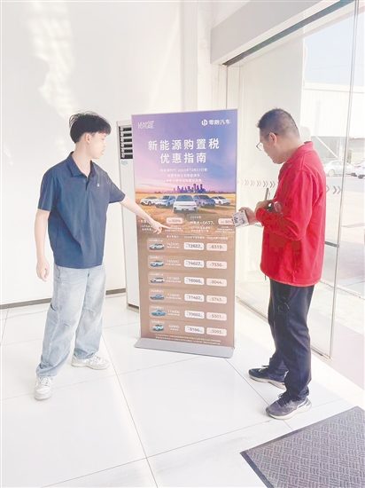 销售人员向市民介绍优惠政策。 销售人员向市民介绍优惠政策。